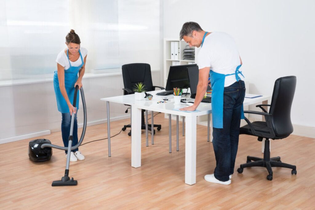 servicemedewerkers die een kantoorruimte aan het schoonmaken zijn